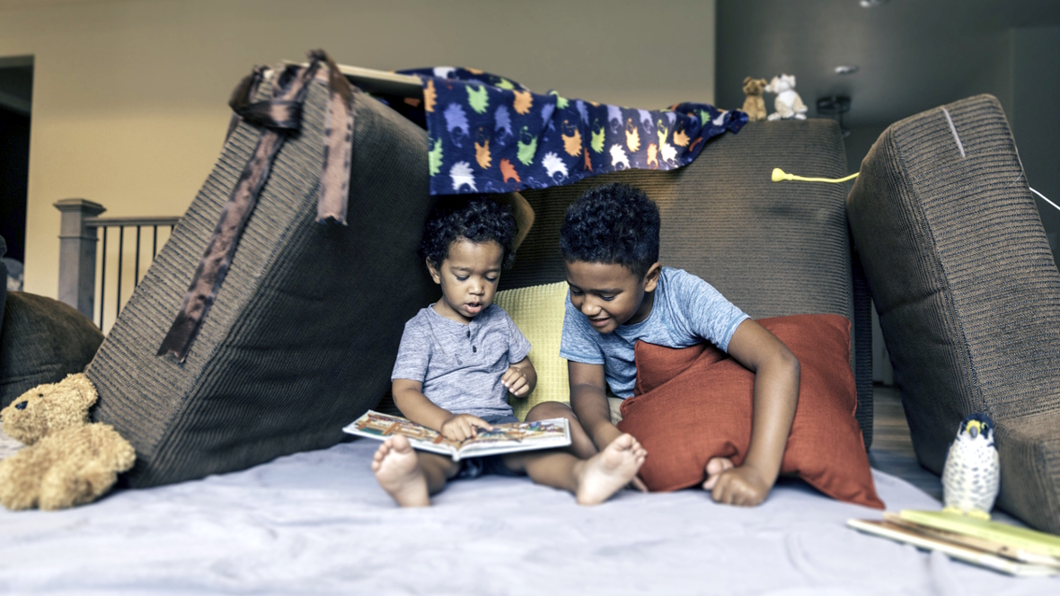 brothers playing in a living room fort