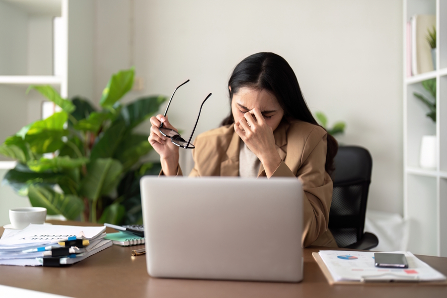 Woman sitting at a desk overwhelmed