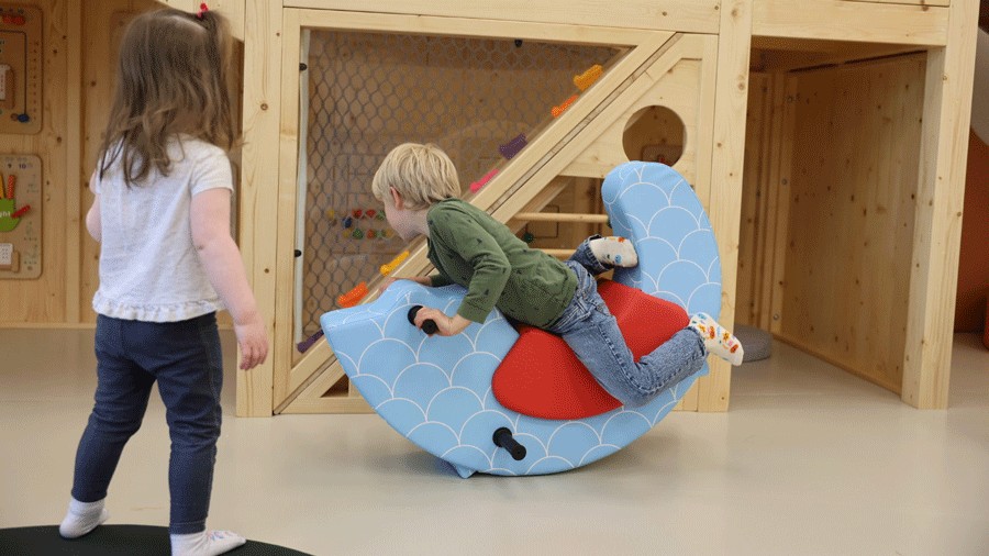young kids playing on the rocking toys and indoor play space at Nixi City