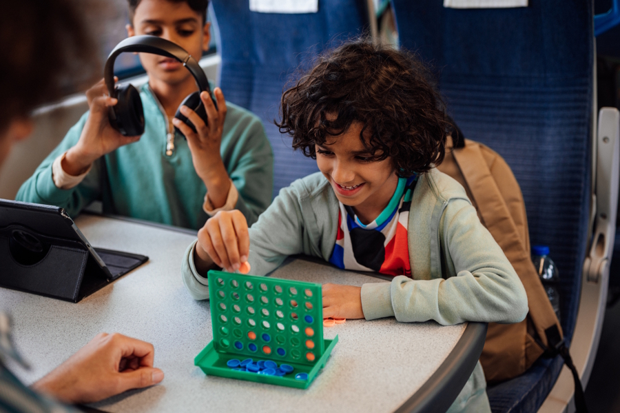 Boy playing a travel game from the tooth fairy on a train