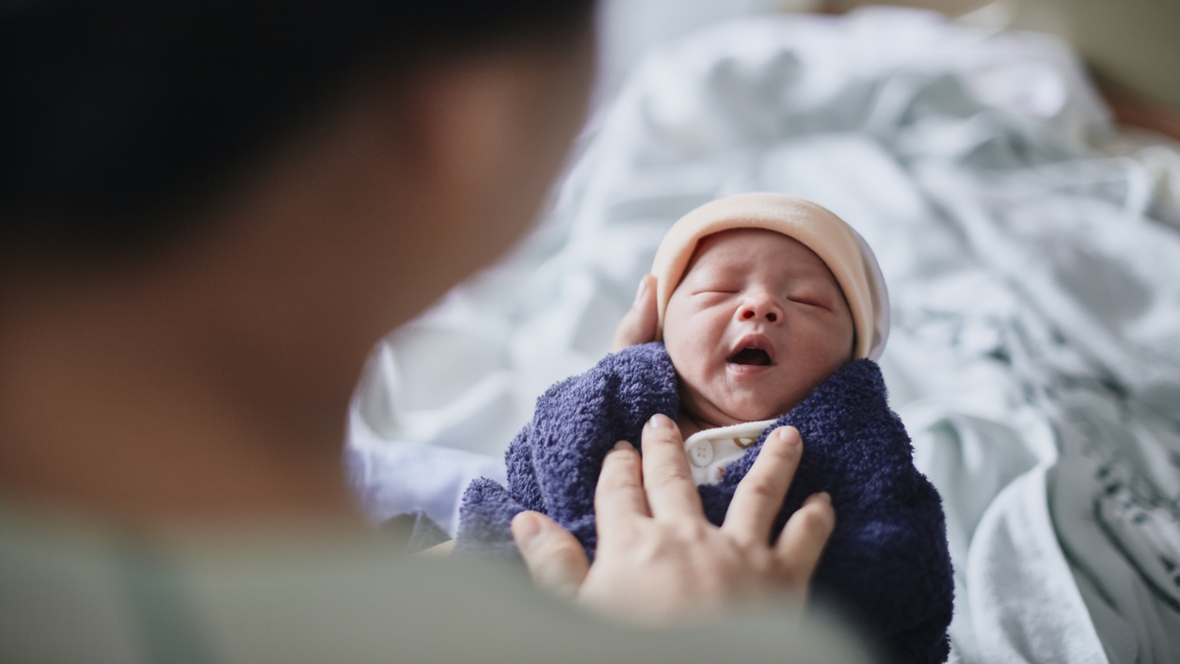 tiny new baby with a hat and blanket