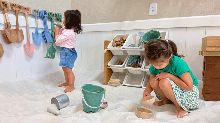 two girls playing with the toys at The Sand Garden