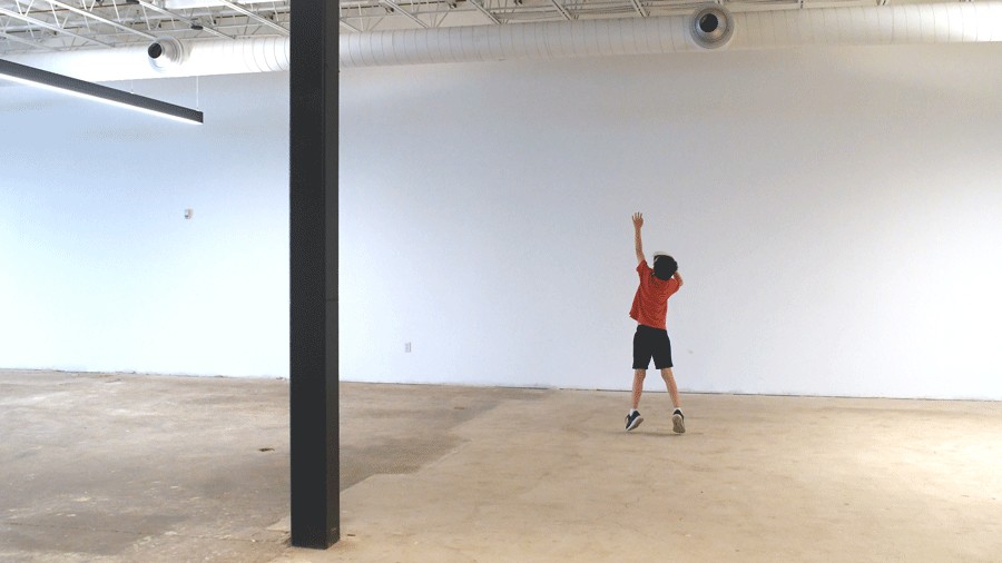 young boy jumping inside an empty warehouse at DreamPark Seattle playing an immersive mixed-reality game