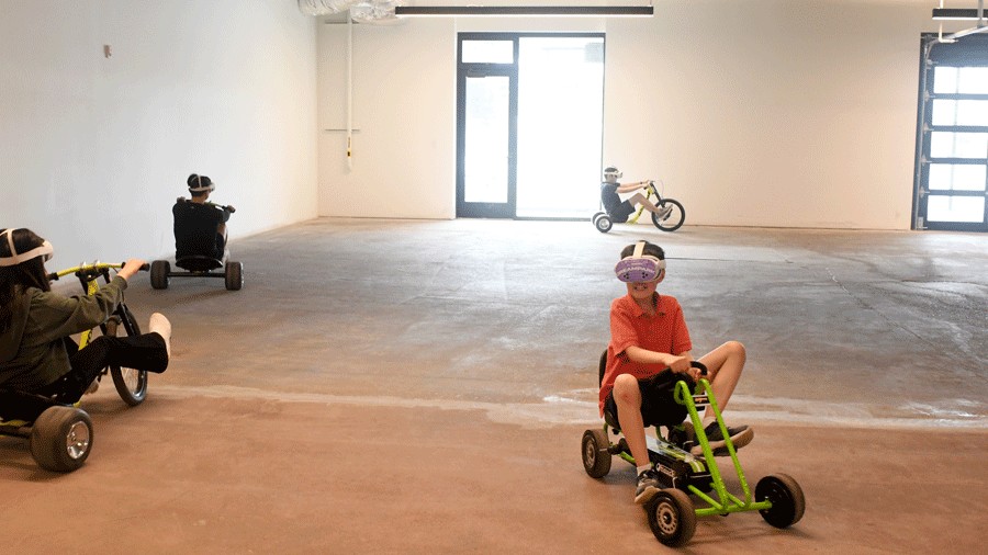 kids riding trikes on the course at DreamPark Seatte, a mixed-reality theme park