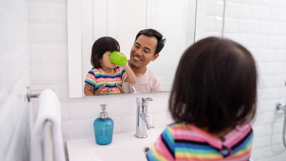 Little girl gargling after brushing her teeth