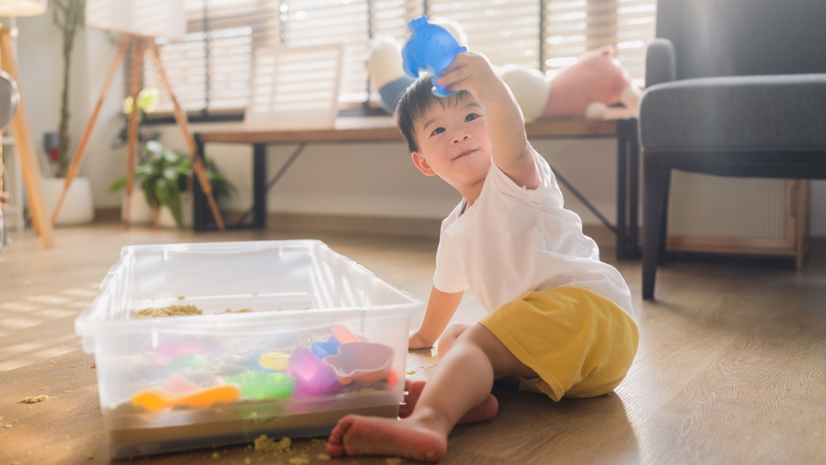 child playing in sand sensory bin