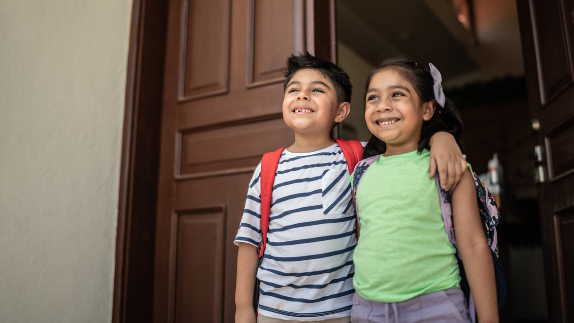Happy brother and sister smiling for a picture on the first day back at school