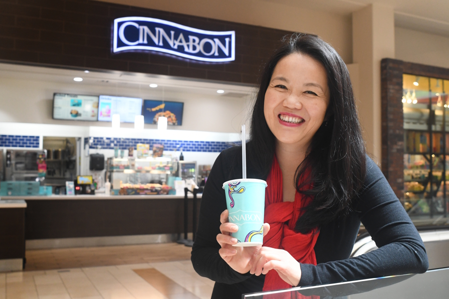 woman holding up a free coffee from Cinnabon