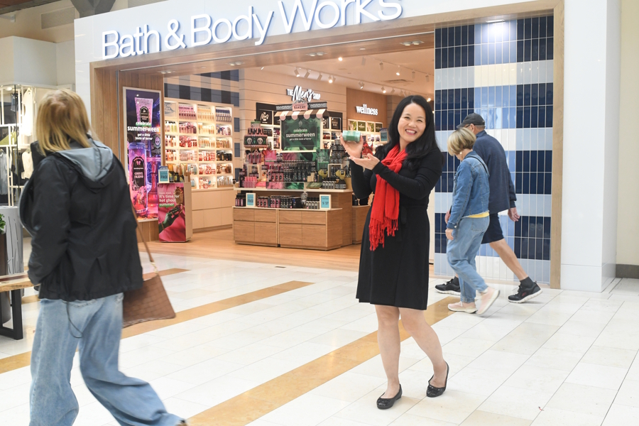 Woman holding up free gift from Bath and Body Works
