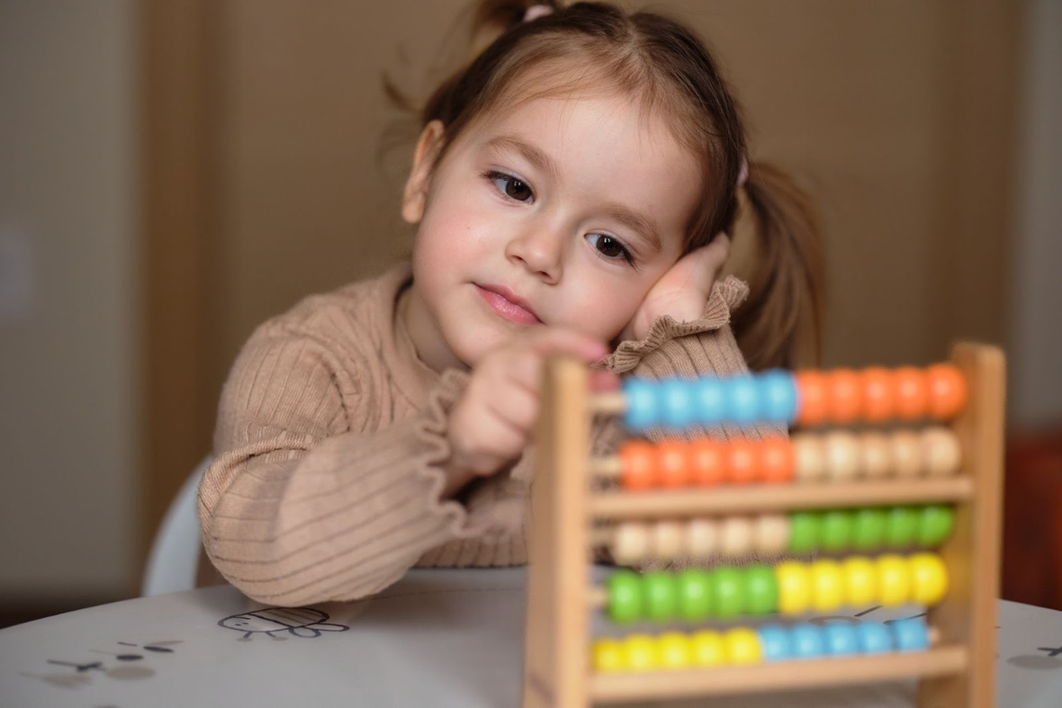 Girl learning how to count on abacus toy