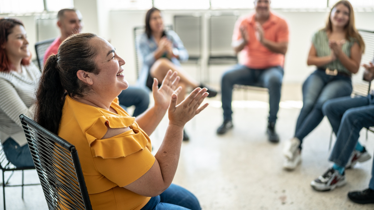 woman in a chair smiling and clapping