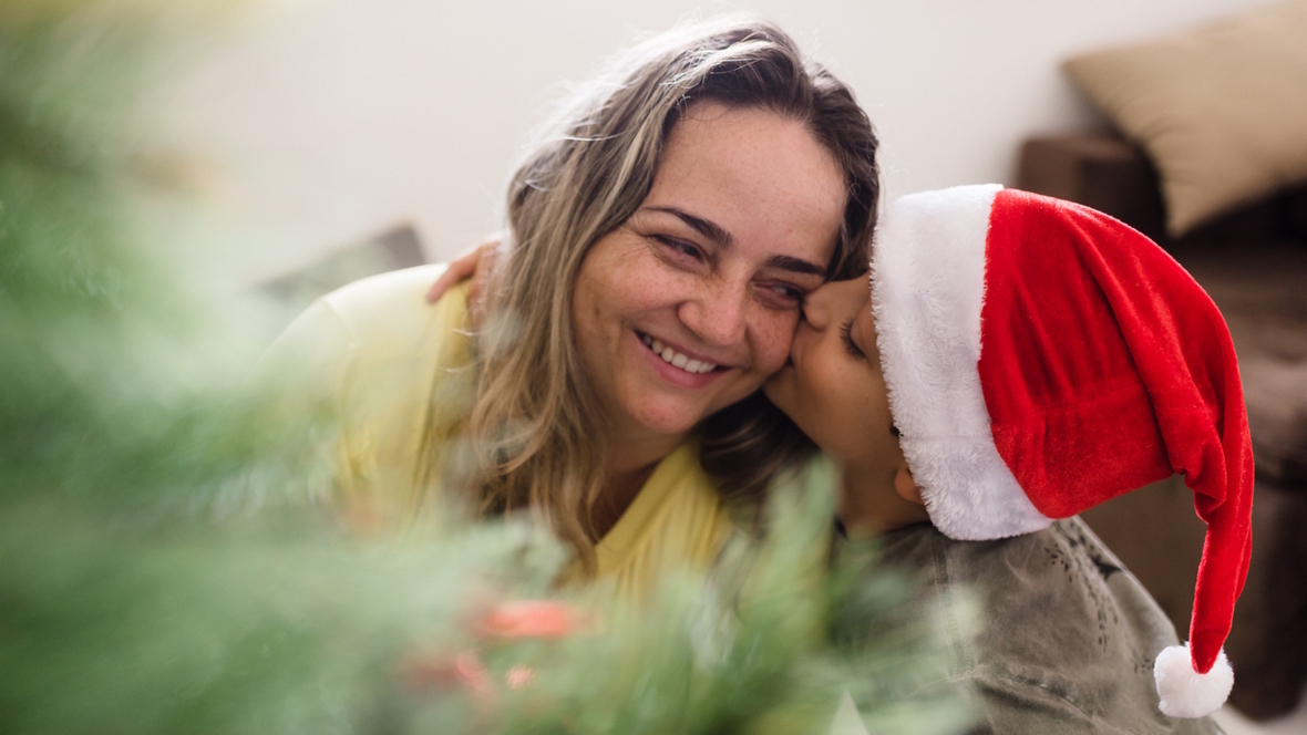 A boy hugs his mom on Christmas morning