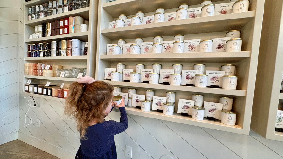 child smelling candles during a make-your-own candle activity in Seabrook during the off-season