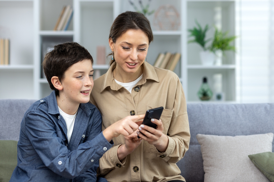 mom and son looking at social media on a phone together