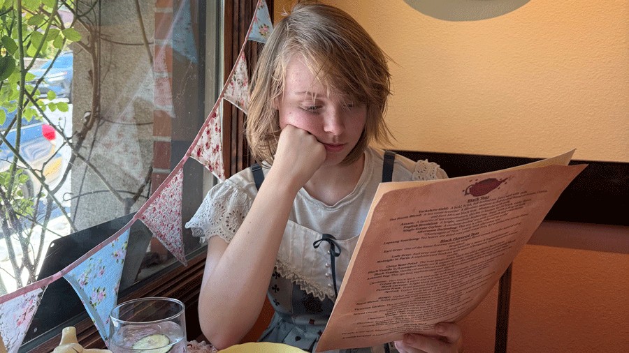 young person reading the menu at Lovejoy's British High Tea in Oregon