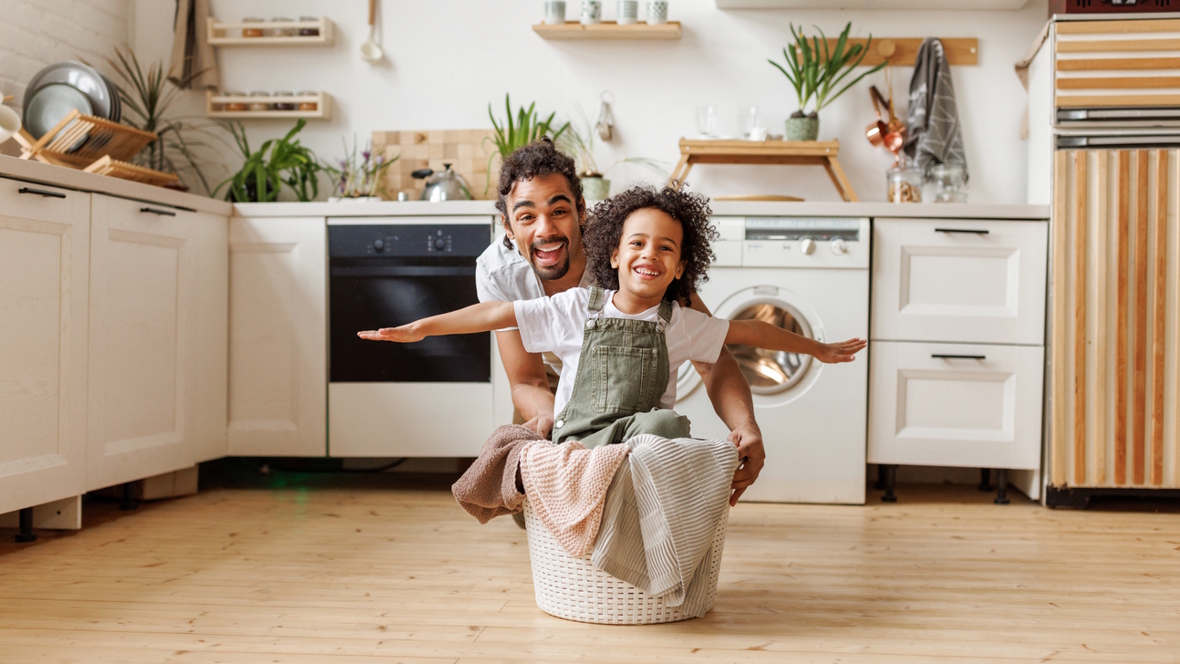 dad and child doing the laundry together having fun
