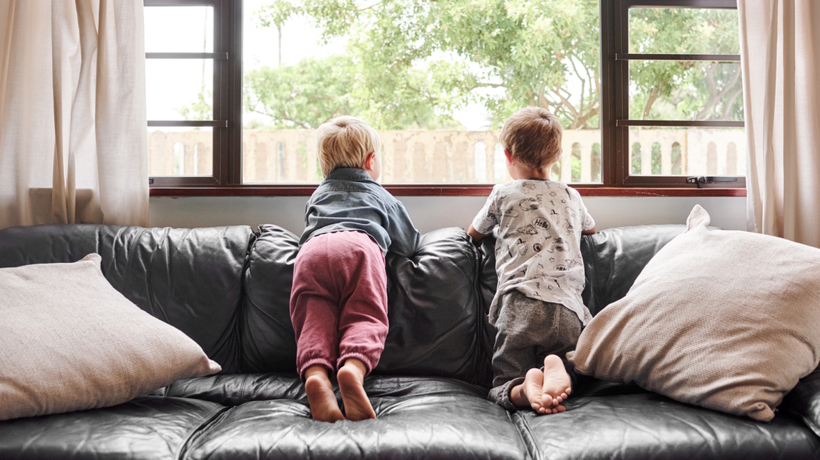 kids sitting on a couch looking outside