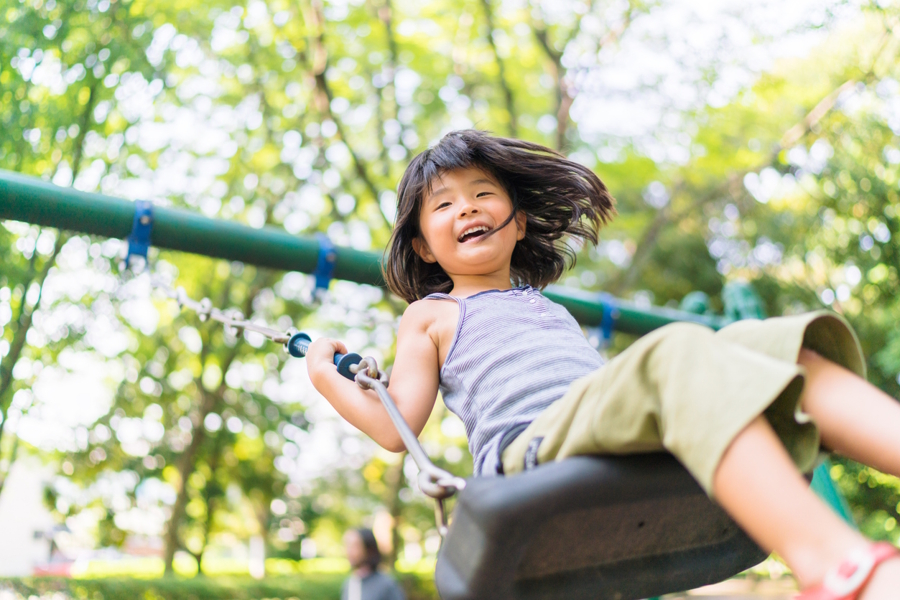 little girl on a swing at the park