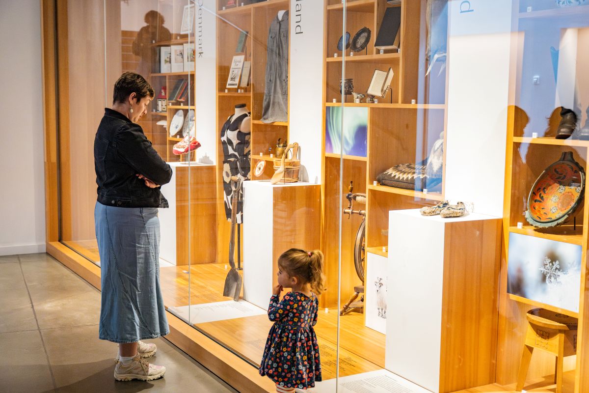girl and mother looking at exhibit through glass at National nordic museum during a free museum day