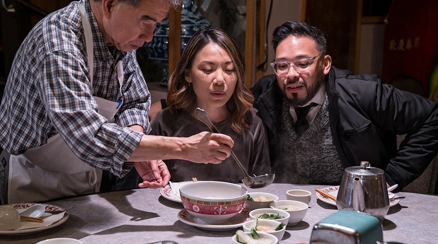 An Asian couple samples some soup on a culinary tour.