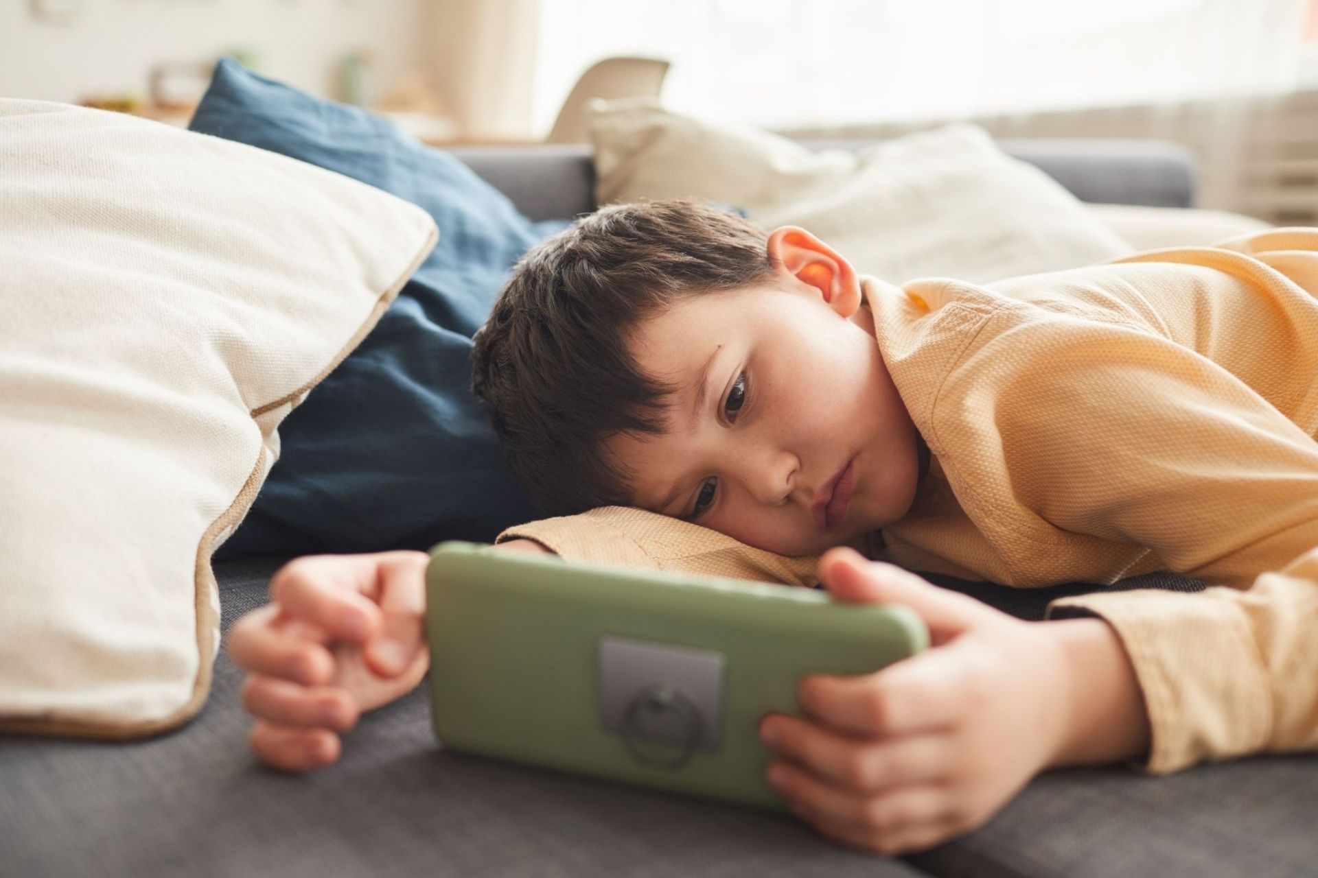 bored little boy using smartphone