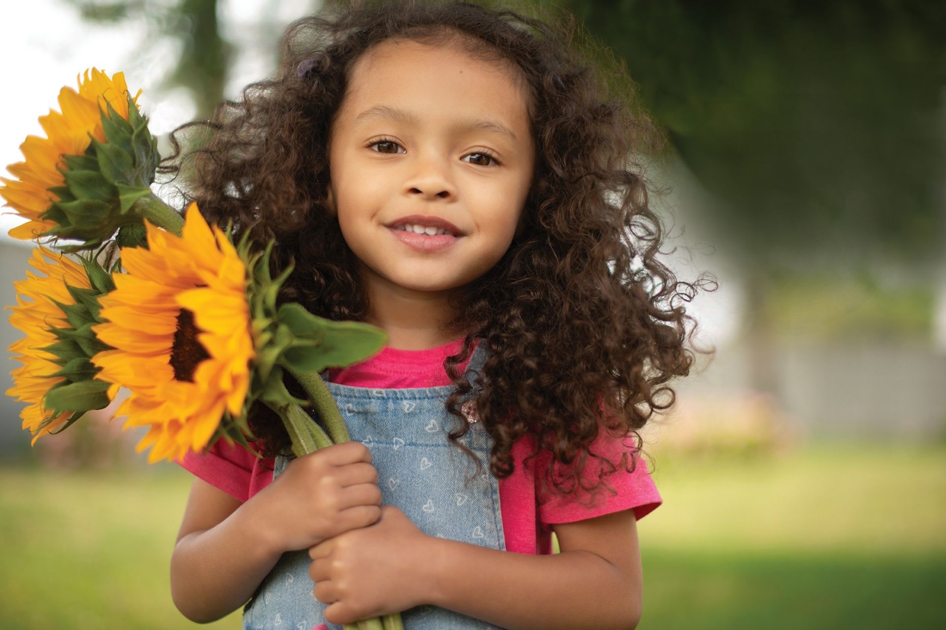 little girl smiling with flowers in hand