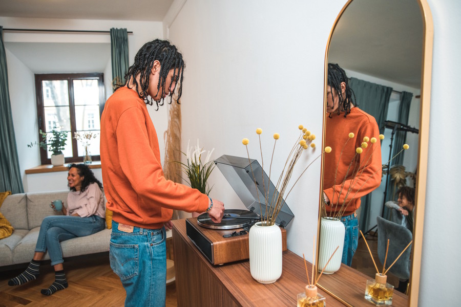 A teen boy is listening to a record with his family