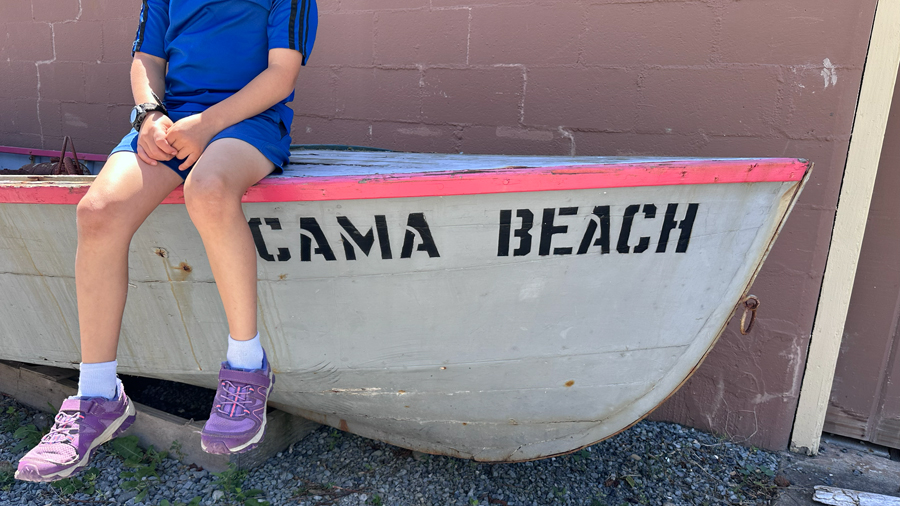 kid sitting on Cama Beach boat on Camano Island