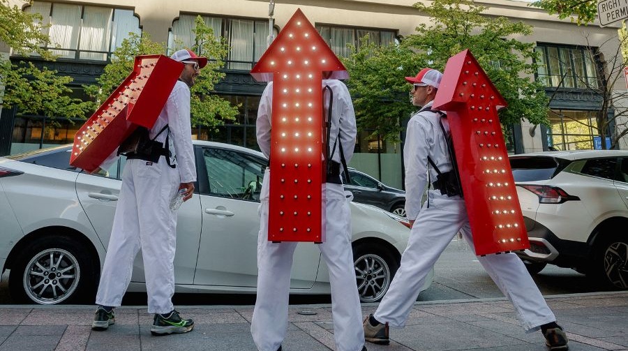 Performers in red arrow costumes perform during a day of public art.