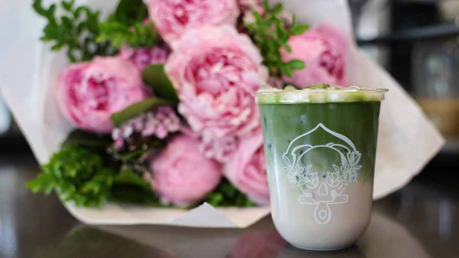 matcha drink in front of pink peonies, both from Pike Place Market attractions