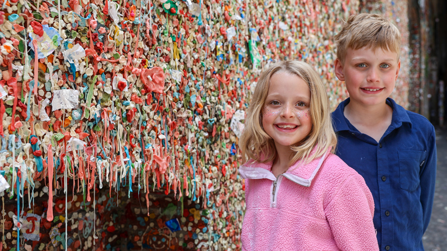 kids posing in front of the Pike Place Market Gum Wall during a day on the waterfront