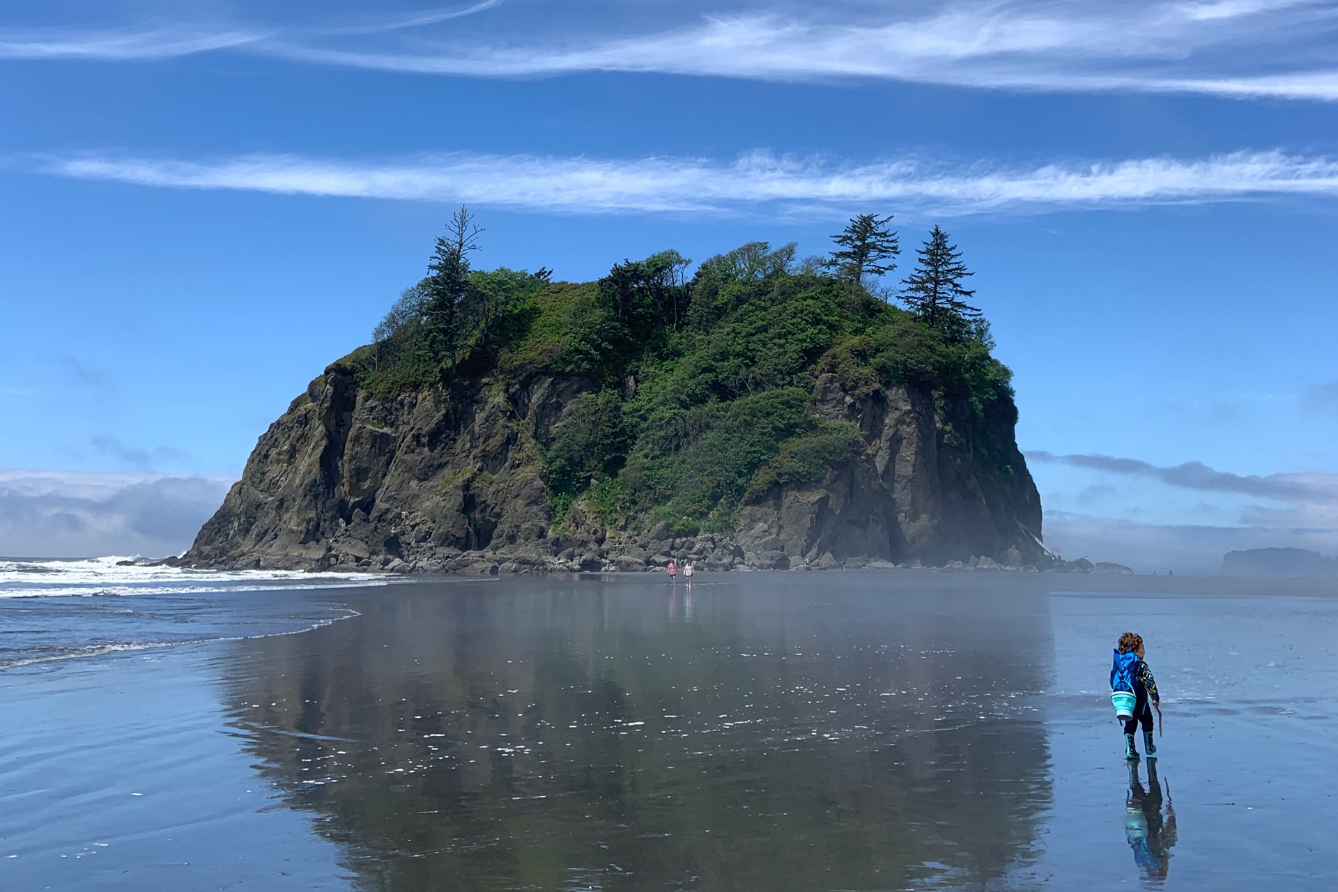 kid walking along the coast of Olympic National Park in the summer
