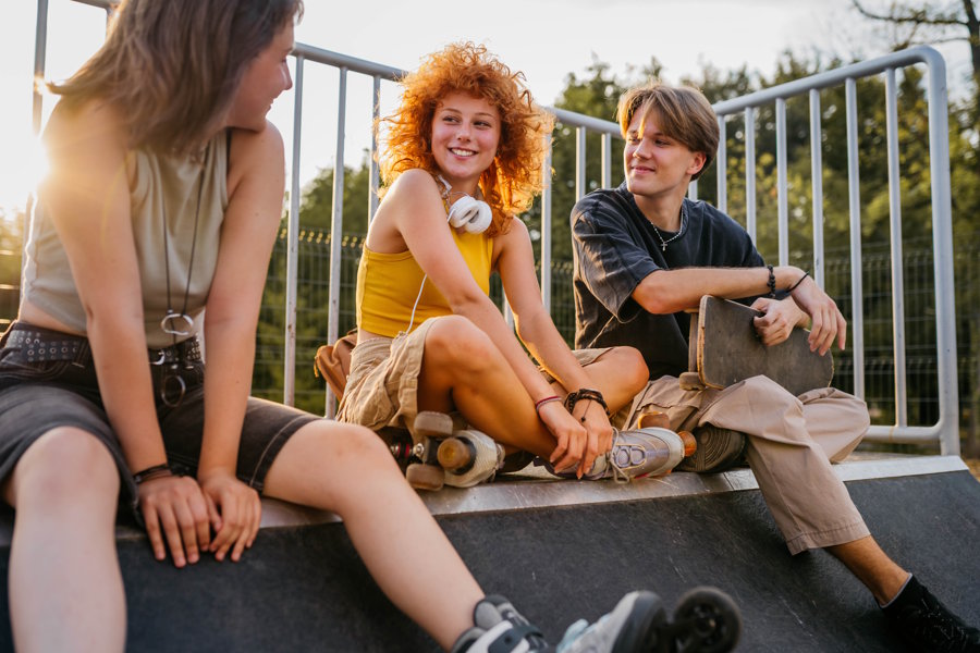 Teens at a skate park talking and smiling