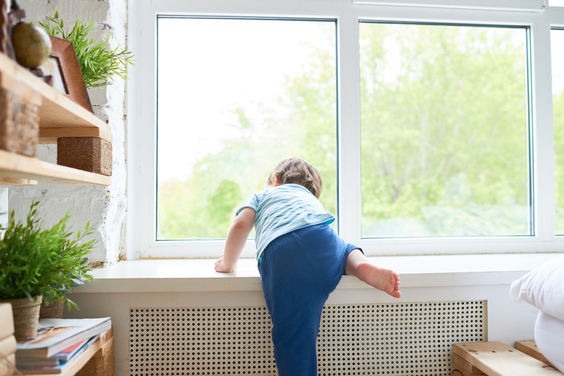 child unsafely climbing on window sill