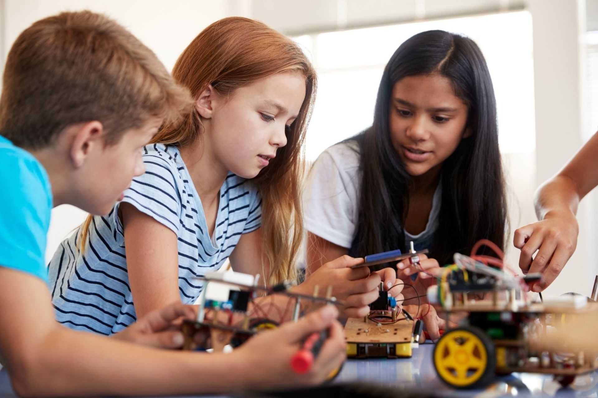 students in a computer club building and learning to program robot vehicle