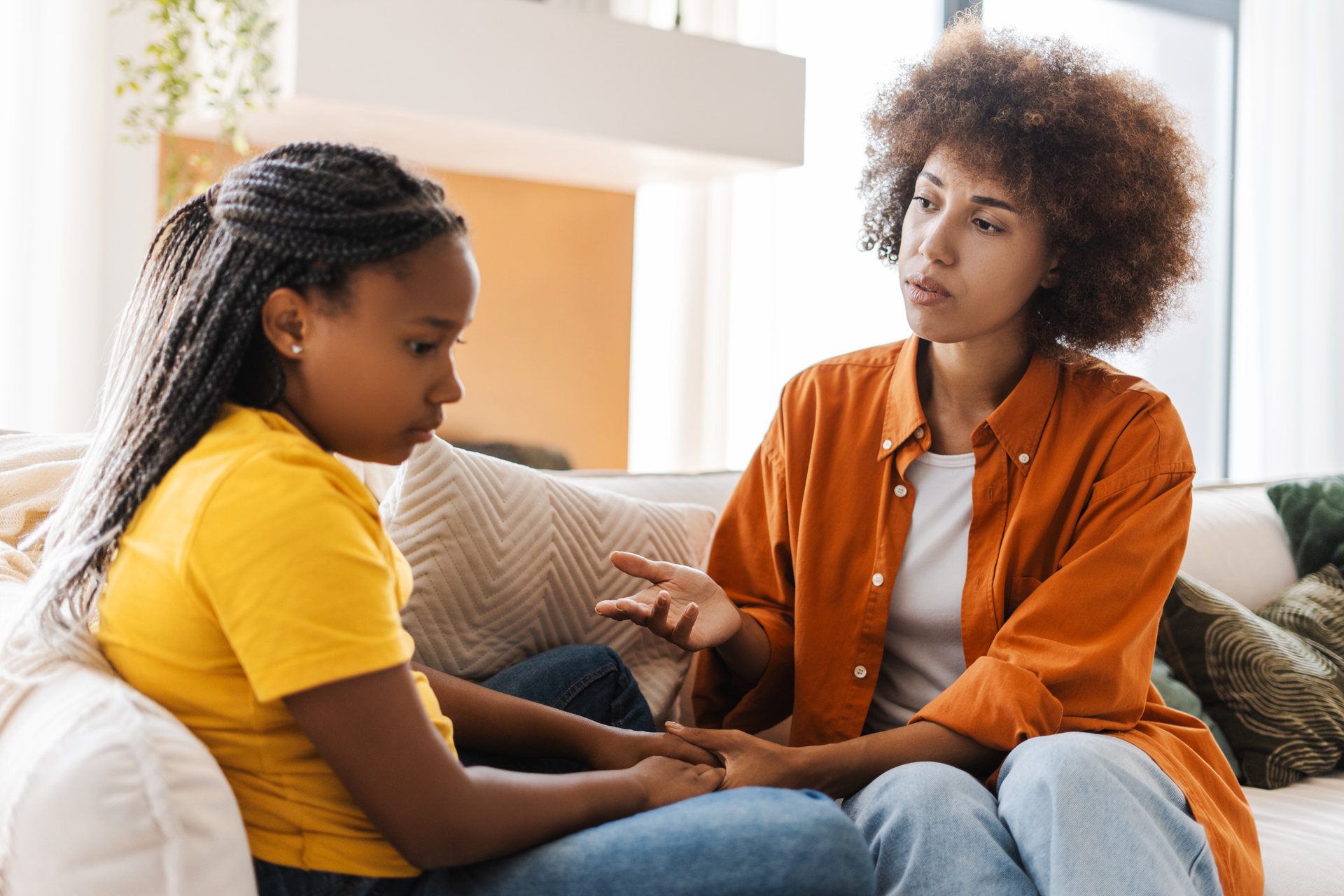 Mother comforts her sad teenage daughter, discussing issues at home.