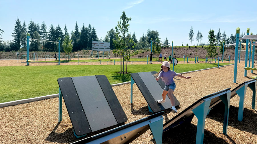 girl completinng an obstacle running across angled steps at the Tehaleh Ruff 'N' Tumble Park
