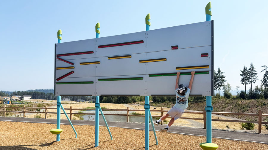 kid gripping onto an obstacle swinging at Tehaleh's new Ruff 'N' Tumble Park