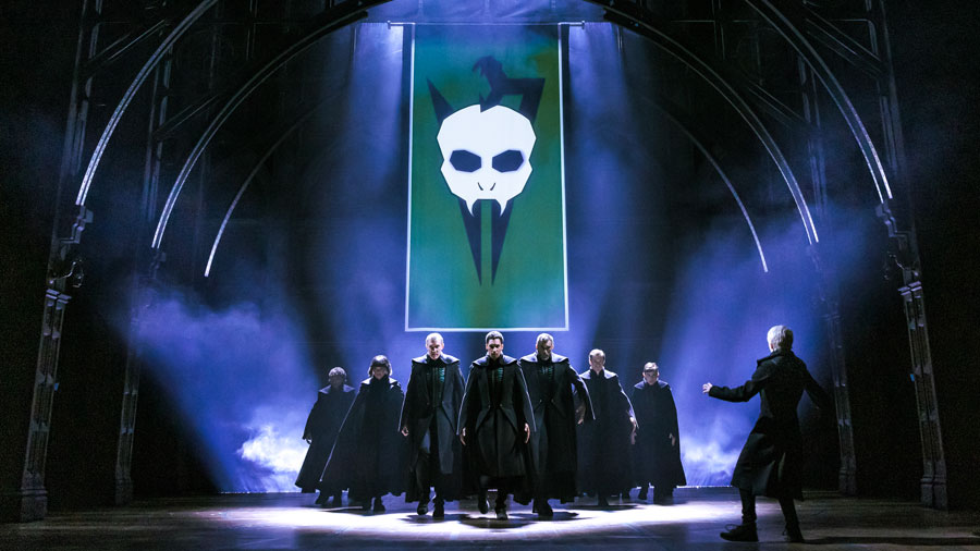 Voldemort forces onstage during "Harry Potter and the Cursed Child" with a large flag behind them