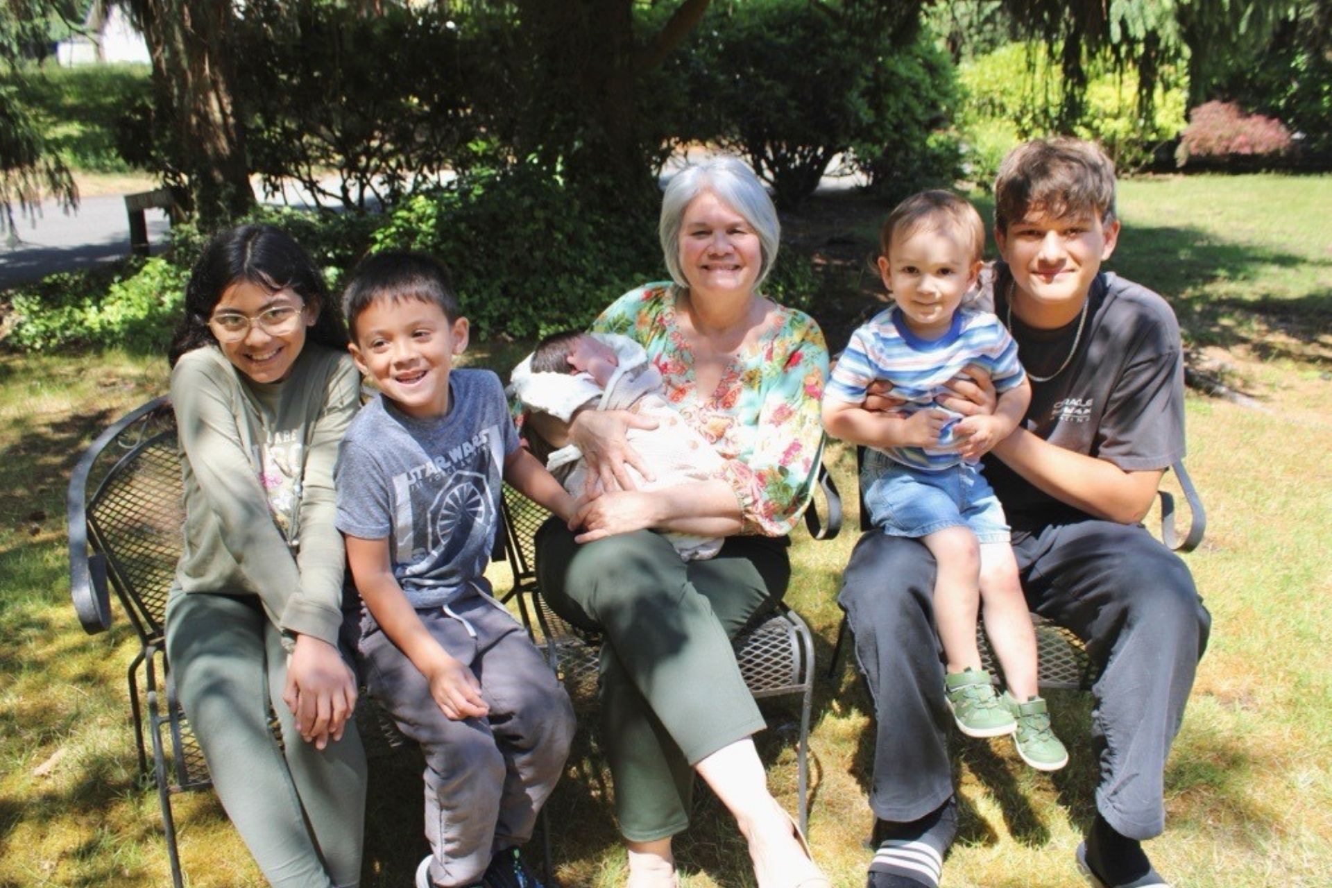 a grandmother with her five grandkids sitting outdoors