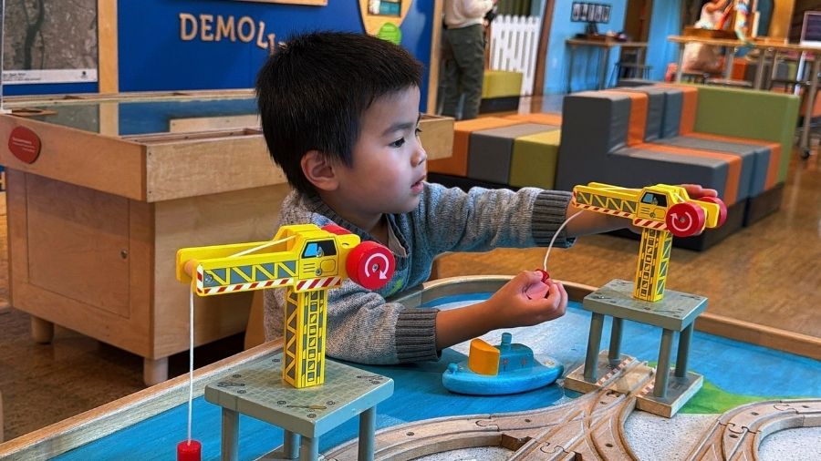 little boy playing hands-on with a construction toy model