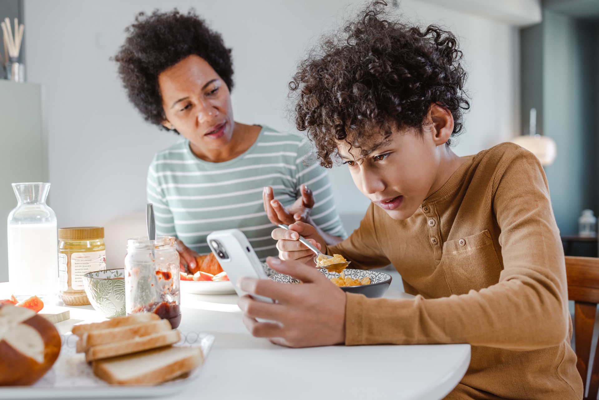 teen screen time device battle with mom and son device used at table