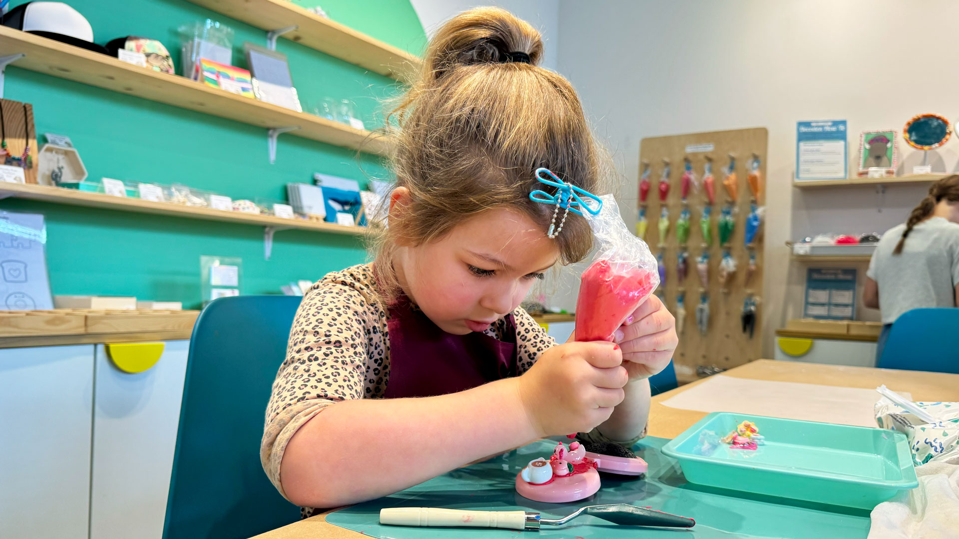 young child works on a Decoden project at Seattle art studio, Robot vs Sloth
