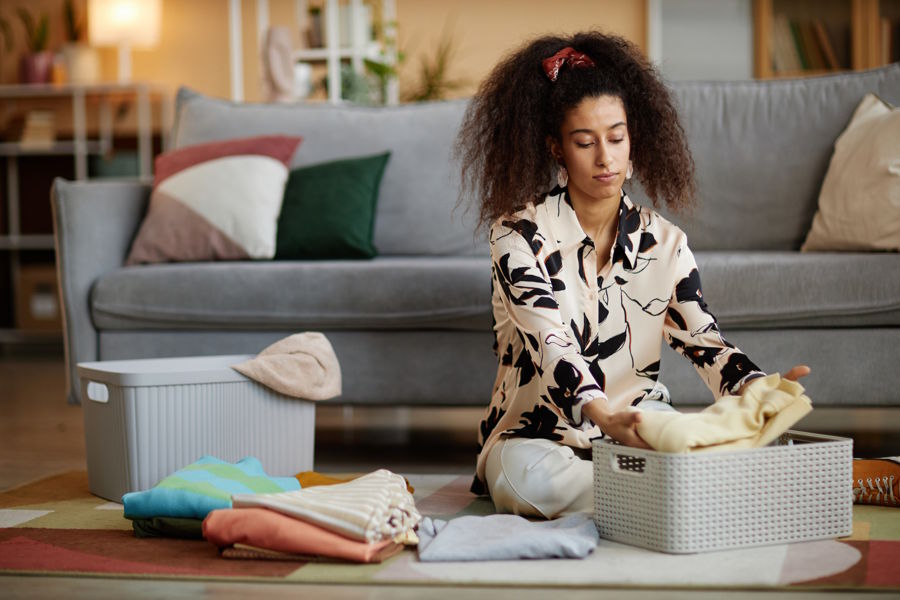 Woman folding clothes and organizing the home where there is no more clutter