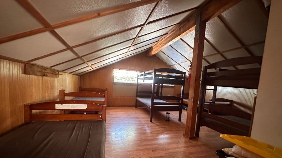 wooden bunk beds inside the shared sleeping loft at copper creek hut on the mount tahoma trails