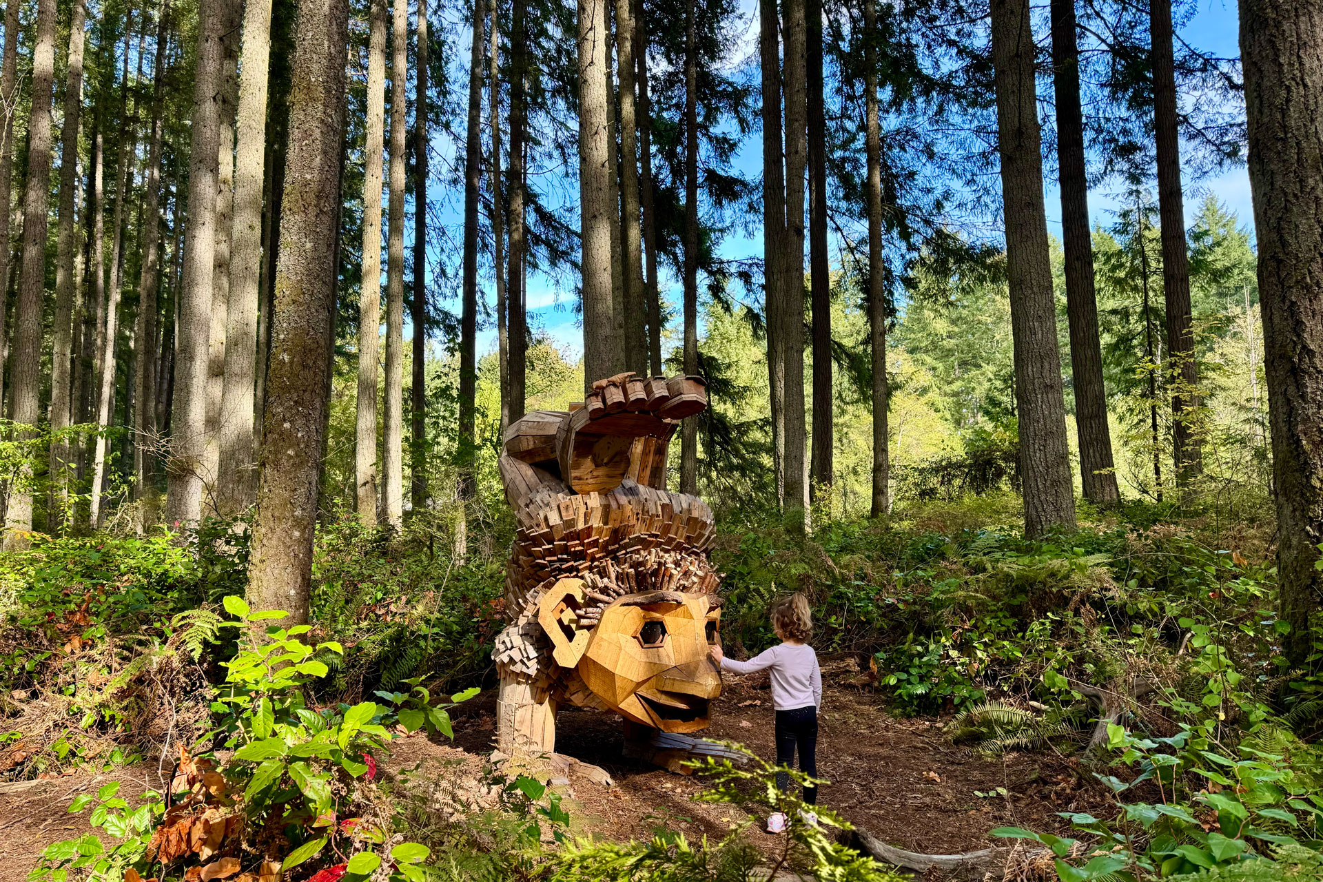 girl standing in front of Kirse, a Thomas Dambo Troll at Northwest Trek Wildlife Park in Washington