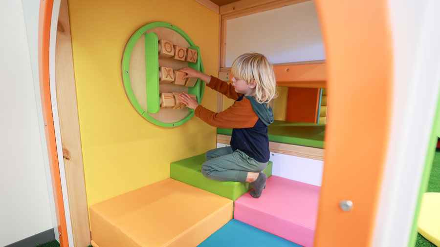 Boy playing tic-tac-toe on a wall at Bright Bean Play Cafe