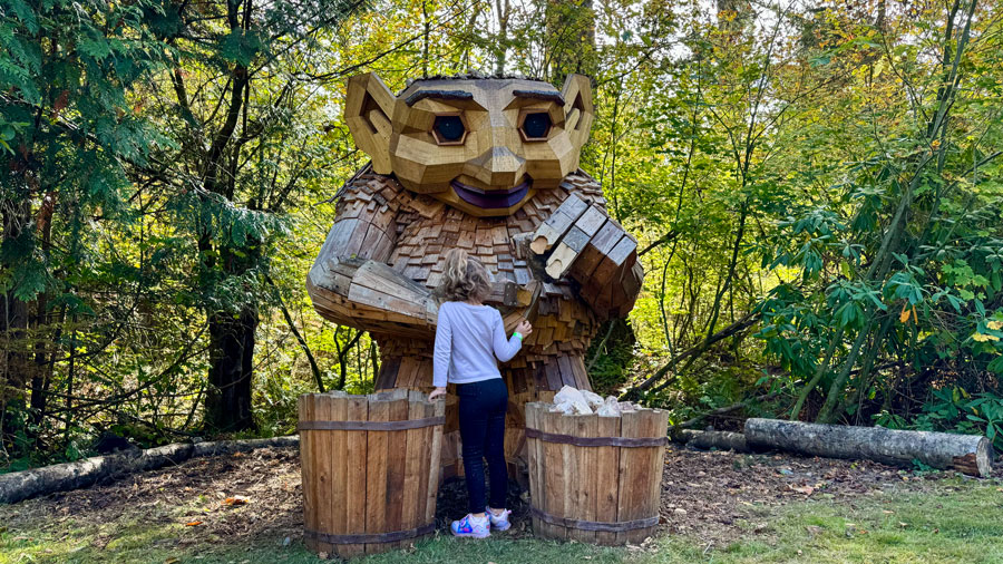 girl touching Thomas Dambo troll at NW Trek