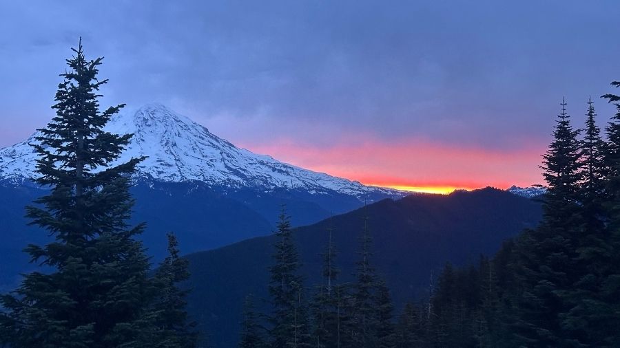 snow-covered mount rainier at sunrise, with pink and orange clouds above the mountains