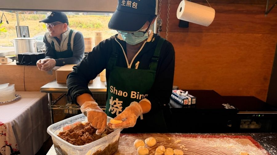 susie sun preparing handmade bao buns at a bite of shanghai in tacoma, a unique restaurant for families